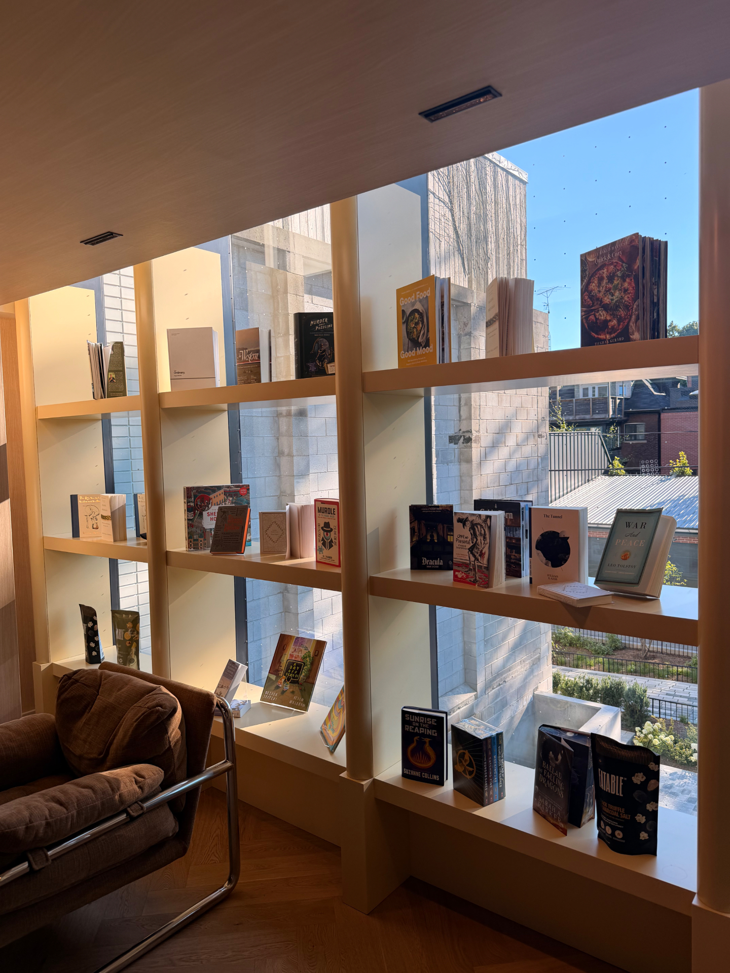 A quiet library with tall wooden shelves and a brown armchair